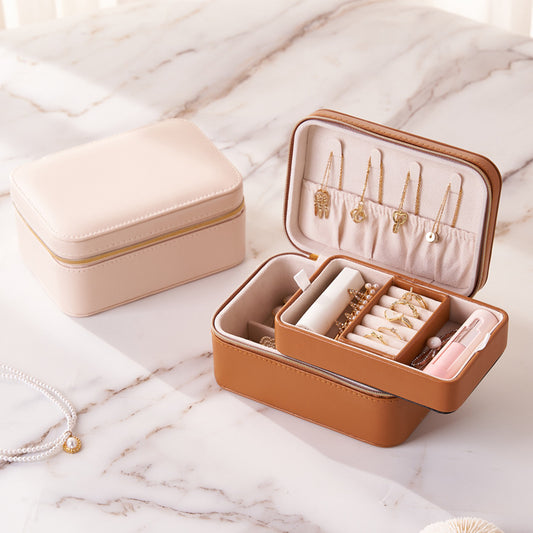 PU leather travel jewelry case closed pink box beside open brown jewellery organizer on marble